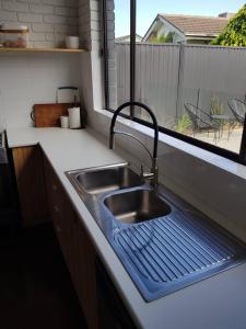 a kitchen sink with a blue mat next to a window at Perfect Large Multi Family Accommodation in Yarrawonga