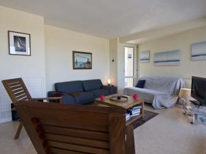 ein Wohnzimmer mit einem blauen Sofa und einem Tisch in der Unterkunft Appartement Les Sables-d'Olonne, 2 pièces, 4 personnes - FR-1-92-649 in La Pironnière