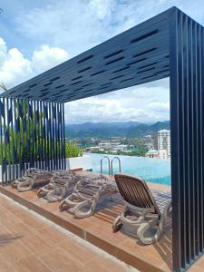 a wooden deck with a chair and a pool at The Horizon by Mykey Global in Ipoh