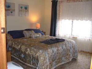 a bedroom with a bed and a window at Kirazz Holiday Homes in Kingscote