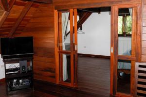 a room with a tv and some glass doors at Baan Chom Chan in Koh Phangan