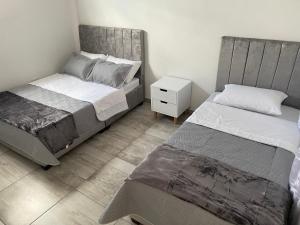 - une chambre avec 2 lits et une table de nuit dans l'établissement The Dreams Alojamineto, à Armenia