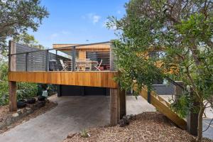 a modern house with a deck and trees at Shangri La - Wifi Included in Inverloch