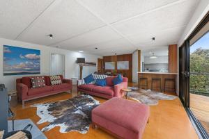 a living room with two couches and a kitchen at Shangri La - Wifi Included in Inverloch