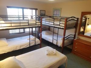 a room with four bunk beds and a mirror at Dalmeny Shores in Dalmeny