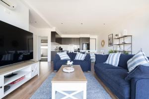 sala de estar con sofá azul y TV en Capel Sound Family Comforts on the Foreshore, en Rosebud