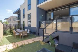 a balcony of a house with a table and chairs at Capel Sound Family Comforts on the Foreshore in Rosebud