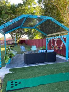 a blue pergola with a couch and a table at Backyard Oasis in Port Saint Lucie