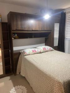 カンピーナスにあるApartamento aconcheganteのベッドと木製のキャビネットのある寝室