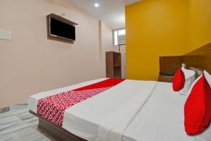 a bedroom with a large bed with red and white sheets at Hotel Rameshwaram in Jaipur