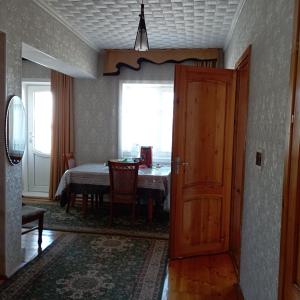 uma porta que leva a uma sala de jantar com uma mesa em Канышай em Osh