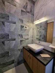 ウダイプールにあるGreen Villa - Peaceful Location, Luxury Rooms - 200 Meters from Bus Stand & 500 Meters from Udaipur City Railway Stationの洗面台と石の壁のあるバスルーム +6枚の写真