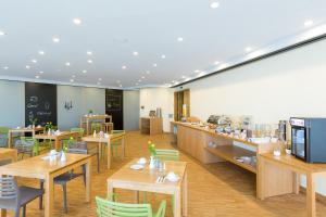 a restaurant with wooden tables and chairs and a cafeteria at mk hotel remscheid in Remscheid