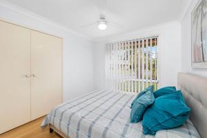 a white bedroom with a bed and a window at 3 Redman Place in Soldiers Point