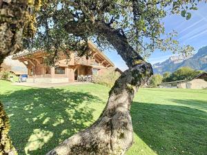 un árbol delante de una casa en Appartement Combloux, 4 pièces, 6 personnes - FR-1-560-65, en Combloux