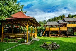 a playground with two large wooden gazebos at Pensiunea Casa Elvira in Vama