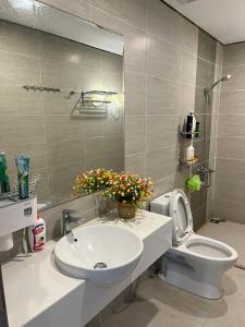 W łazience znajduje się umywalka, toaleta i lustro. w obiekcie VĂN MINH - TIỆN NGHI - SANG TRỌNG w mieście Gò Công
