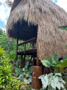 a small hut with a thatched roof at Sten Lodge eco Homestay in Labuan Bajo