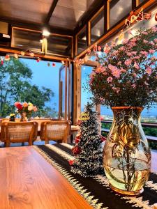 un vase rempli de fleurs assis sur une table dans l'établissement ภูเพียงพอ ณ เชียงราย, à Chiang Rai