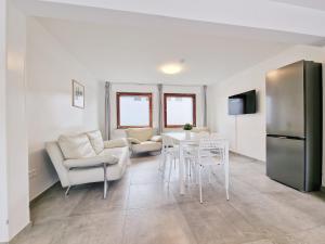 a living room with a table and chairs and a refrigerator at RAJ Living - 6 Room House with Terrace and Parking - 25 Min Messe DUS & Airport DUS in Duisburg
