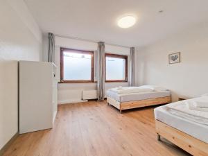 a bedroom with two beds and a refrigerator at RAJ Living - 6 Room House with Terrace and Parking - 25 Min Messe DUS & Airport DUS in Duisburg