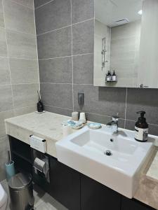 a bathroom with a white sink and a mirror at Eastern View Premium Residence in Ulsan