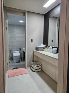 a bathroom with a toilet and a sink and a mirror at Eastern View Premium Residence in Ulsan