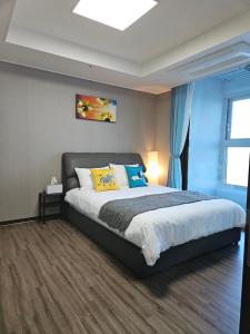 a bedroom with a large bed with blue curtains at Eastern View Premium Residence in Ulsan