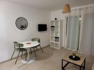 LinguizzettaにあるResidence Marina di Bravoneの白いテーブルと椅子のあるリビングルーム