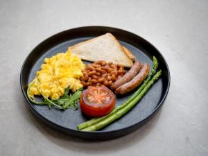 um prato de comida de pequeno-almoço com ovos, feijão de salsicha e torradas em One O Eight Boutique Hotel em Benoni