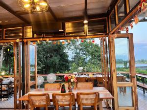 un comedor con mesas y sillas y una gran ventana en ภูเพียงพอ ณ เชียงราย en Chiang Rai