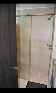 a shower with a glass door in a bathroom at Hermoso y tranquilo apartasuite in Floridablanca