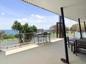 a balcony with a table and chairs and a view of the ocean at First Point Down by Discover Stradbroke in Point Lookout