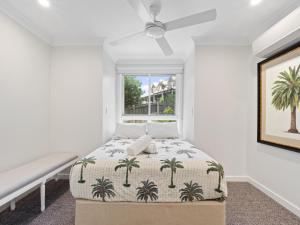 a bedroom with a bed and a window at First Point Down by Discover Stradbroke in Point Lookout