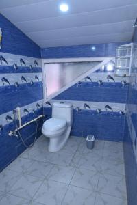 een blauwe badkamer met een toilet in een kamer bij Om Niwas Homestay in Shimla