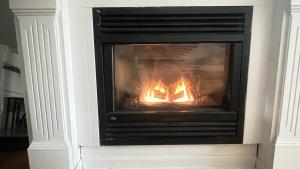 a fireplace in a living room with a fire in it at heart of Kitsilano area,5 mins walk to kits beach in Vancouver