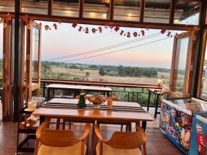a table and chairs on a balcony with a view at ภูเพียงพอ ณ เชียงราย in Chiang Rai