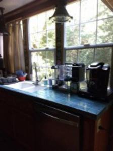 a kitchen counter with a sink and a window at The Storybook Cottage in Mendocino