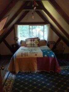 een slaapkamer met een bed op zolder bij The Storybook Cottage in Mendocino