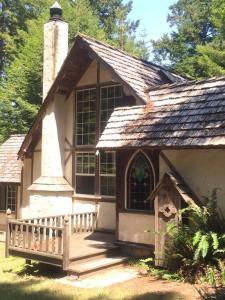 a small house with a porch and a large window at The Storybook Cottage in Mendocino