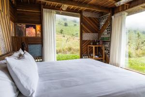 een slaapkamer met een groot bed en een groot raam bij Mamallacta Páramo Lodge in Papallacta +210 foto's