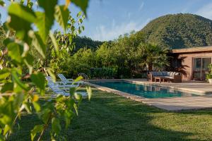 a swimming pool with chairs and a house at Callihue Lodge in Santa Cruz