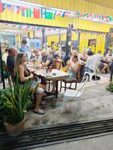 een groep mensen die aan tafel zitten in een restaurant bij Haadrin village Fullmoon in Haad Rin