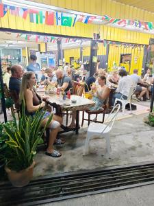 un grupo de personas sentadas en mesas en un restaurante en Haadrin village Fullmoon en Haad Rin