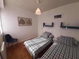 a bedroom with two beds and a chair at Villa Patio Charmante, 2 Pas des Plages, Terrasse, Parking, Piste Cyclable - FR-1-239-892 in Capbreton