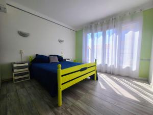een slaapkamer met een geel bed en een groot raam bij Appartement Argelès-sur-Mer, 2 pièces, 4 personnes - FR-1-309-371 in Argelès-sur-Mer