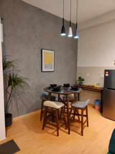 uma cozinha com uma mesa e bancos num quarto em Kuantan Homestay by WyattHomes em Kuantan