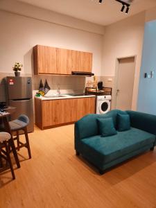 uma sala de estar com um sofá e uma cozinha em Kuantan Homestay by WyattHomes em Kuantan
