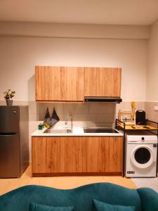 uma cozinha com armários de madeira e um lavatório em Kuantan Homestay by WyattHomes em Kuantan