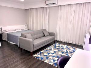 a bedroom with a bed and a couch and a rug at Flat Hotel de luxo em Moema, São Paulo in São Paulo +23 photos
